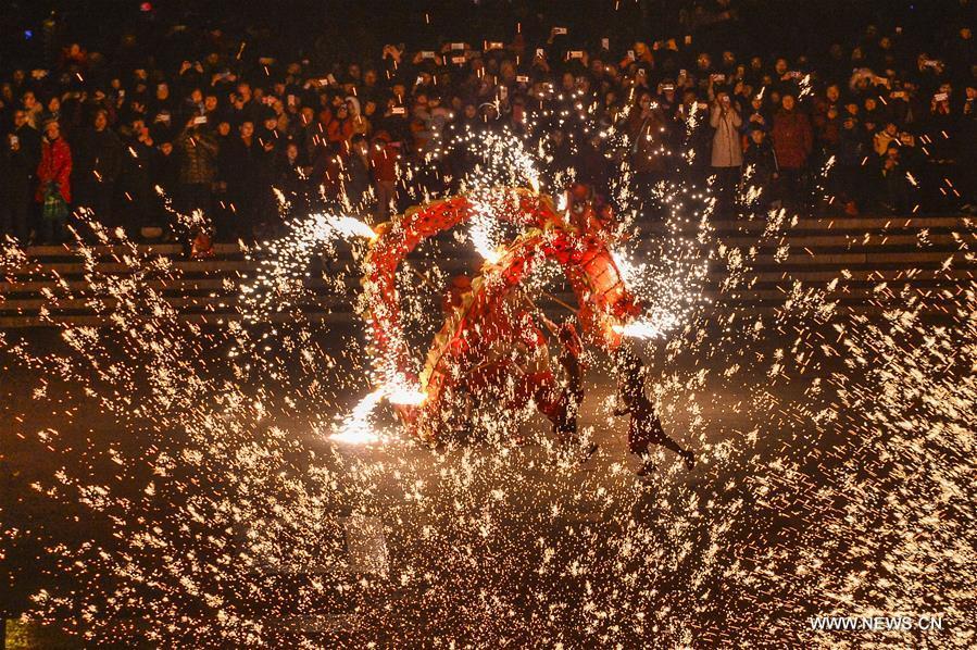 People perform a fire dragon dance in a shower of molten iron sparkling like fireworks to welcome the Spring Festival in Taierzhuang ancient town in Zaozhuang, east China\'s Shandong Province, Feb. 16, 2018. (Xinhua/Gao Qimin)