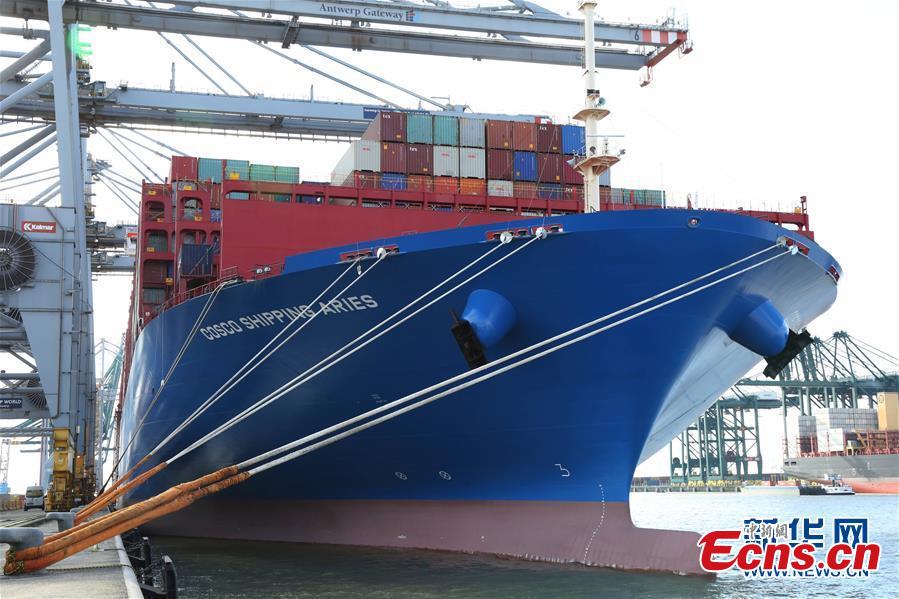 China\'s colossal container vessel COSCO Shipping Aries docks at the Port of Antwerp in Belgium during its maiden voyage, Feb. 27, 2018. The 20,000 TEU vessel is the first ultra-large containership built and operated by a Chinese company. COSCO Shipping Aries is 400 meters long, 58.6 meters wide and 30.7 meters high, with a maximum load capacity of 197,000 tons. Its deck area is larger than four standard soccer stadiums. (Photo/Xinhua)
