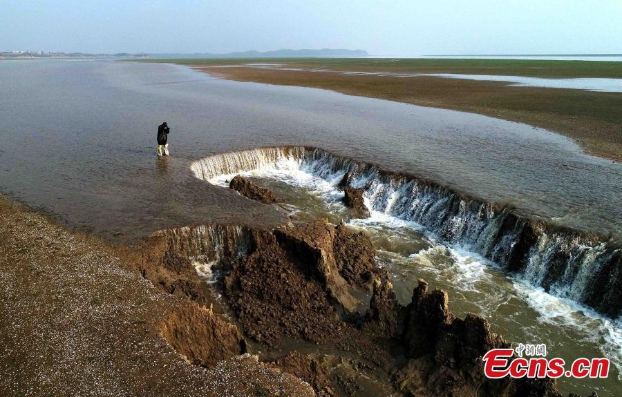 A view of a two-meter-high waterfall formed after a cave-in at the Damianchi Wetland, part of Poyang Lake in Duchang County, East China\'s Jiangxi Province, March 15, 2018. The largest fresh water lake in China has seen continuous rainfall in recent times. (Photo: China News Service/Yang Fan)