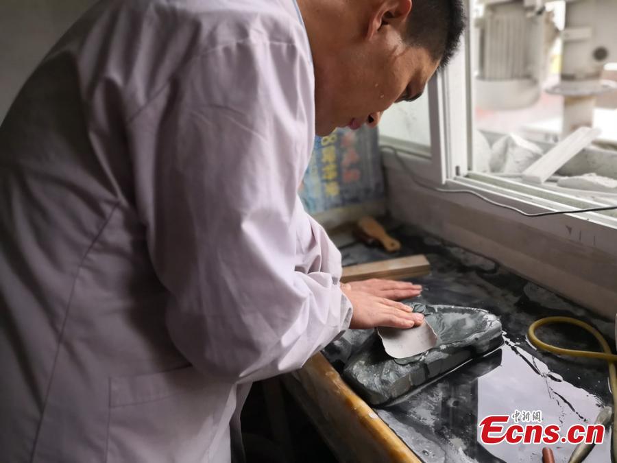 Huang Bingqiang puts the final touch on a Tao inkstone at Shangchuan village in Lanzhou City, Northwest China\'s Gansu Province, March 21, 2018. Huang has been a dedicated maker of Tao inkstones for 15 years. With a 1,300-year-old history, Tao inkstones, made of stone found on the bed of the Tao River, is known as one of four famous inkstones in China and favored by traditional Chinese scholars. Huang needs up to ten days to finish a Tao inkstone, an act that involves tens of time-consuming steps. (Photo: China News Service/Yang Na)