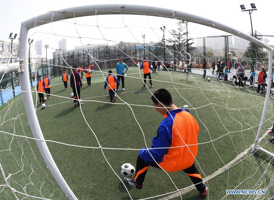 Autistic children play football on the football field at Xinnan Community in Lianyungang City, east China\'s Jiangsu Province, April 1, 2018. A football team, composed of 22 autistic children aging from 7 to 16, was jointly set up by the community and an autism care center ahead of the World Autism Awareness Day, which falls on April 2 every year. The football team will have trainings and games every week. (Xinhua/Geng Yuhe)