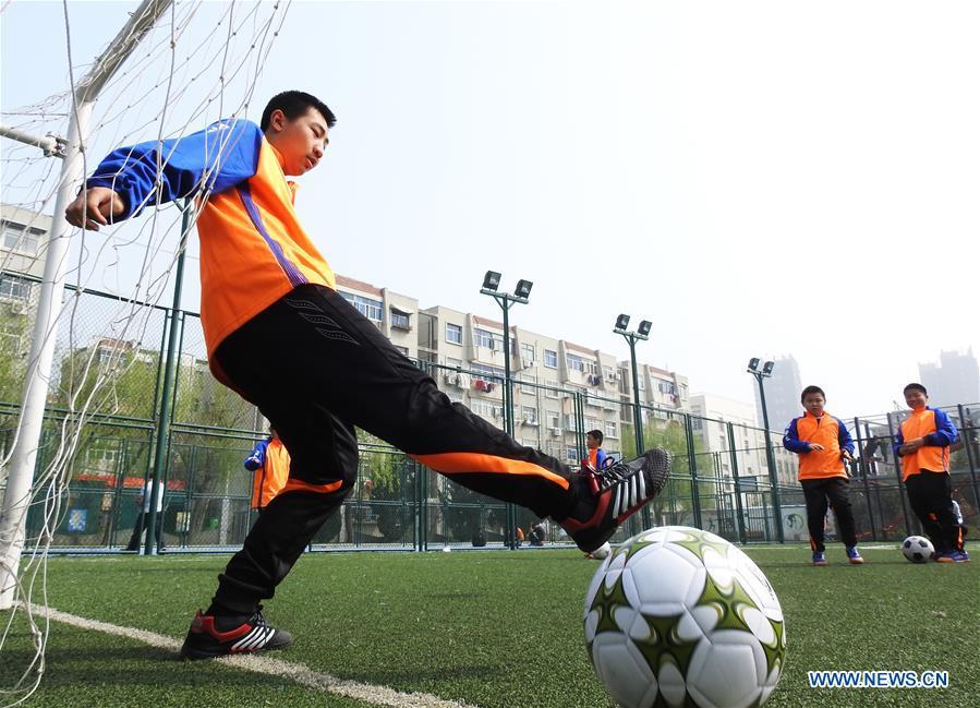 Autistic children play football on the football field at Xinnan Community in Lianyungang City, east China\'s Jiangsu Province, April 1, 2018. A football team, composed of 22 autistic children aging from 7 to 16, was jointly set up by the community and an autism care center ahead of the World Autism Awareness Day, which falls on April 2 every year. The football team will have trainings and games every week. (Xinhua/Geng Yuhe)