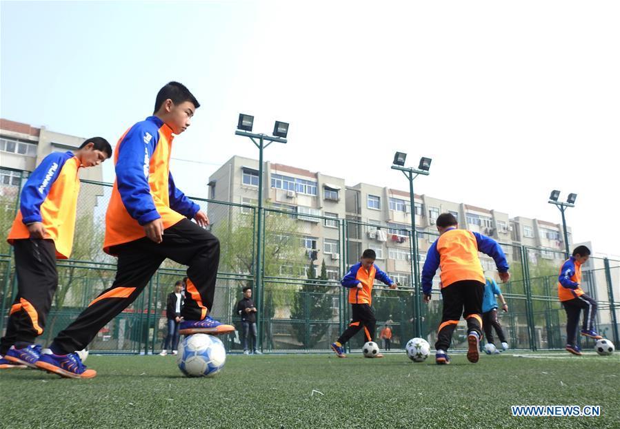Autistic children play football on the football field at Xinnan Community in Lianyungang City, east China\'s Jiangsu Province, April 1, 2018. A football team, composed of 22 autistic children aging from 7 to 16, was jointly set up by the community and an autism care center ahead of the World Autism Awareness Day, which falls on April 2 every year. The football team will have trainings and games every week. (Xinhua/Geng Yuhe)