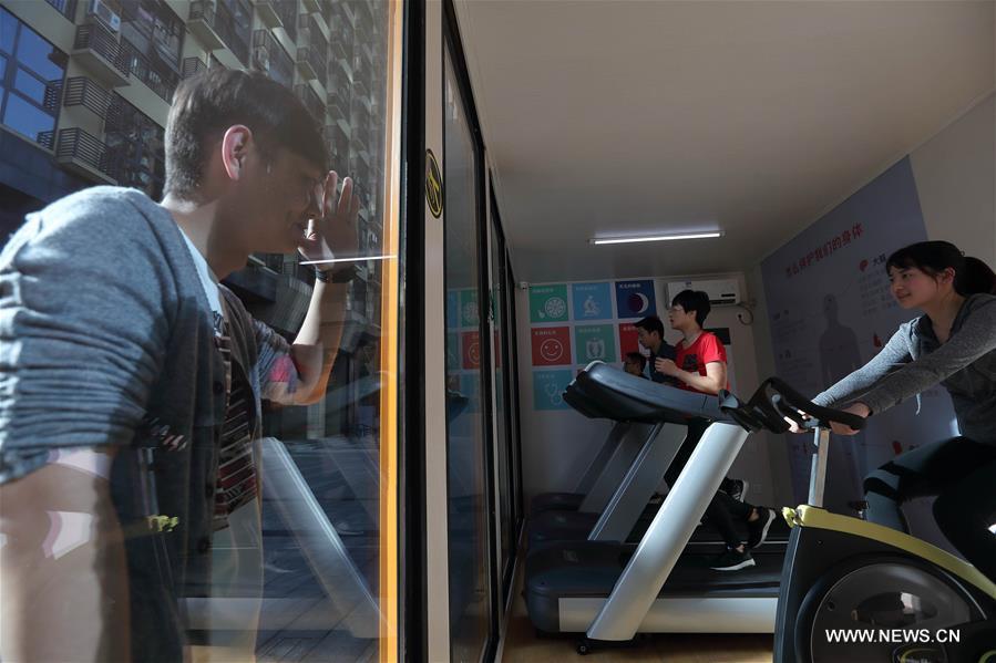 A man looks inside the shared gym in Chengdu, southwest China\'s Sichuan Province, April 2, 2018. The 24 hour shared gym in Chengdu is equipped with air purifier, air conditioner and water dispenser. People can exercise here by scanning the QR code. (Xinhua/Jiang Hongjing)
