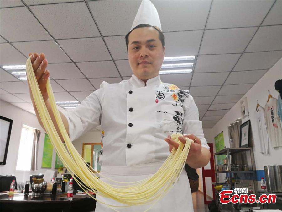 Terry Wu from Spain shows Lanzhou hand-pulled beef noodles at a workshop in Lanzhou City, Northwest China\'s Gansu Province. Some foreigners from Spain, Germany, Bangladesh and Kazakhstan learned about making Lanzhou Lamian to understand Chinese culture. Lamian is made by repeatedly twisting, stretching and folding the dough into strands at various lengths and thicknesses. (Photo: China News Service/Shi Jingjing)