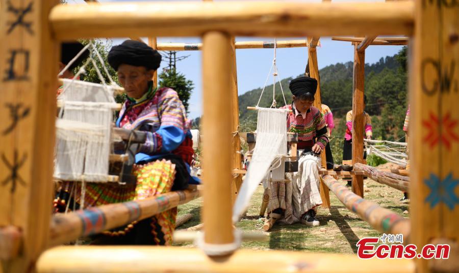 Women of the Lisu ethnic group demonstrate the process of making traditional clothes using two types of plants in Dechang County, Southwest China\'s Sichuan Province, April 11, 2018. The ancient craft of making the clothes using purely natural materials is rapidly declining. The process involves tens of steps, such as collecting the plant, making thread and weaving. (Photo: China News Service/Liu Zhongjun)