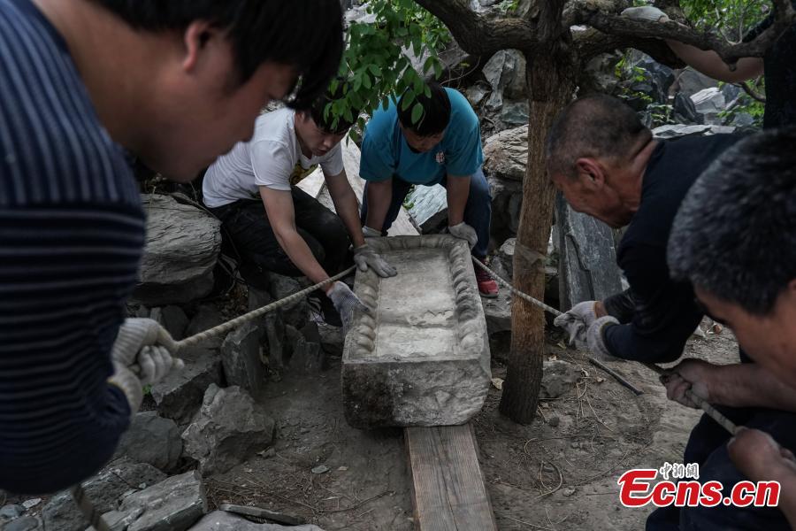 A stone tablet with Emperor Qianlong\'s hand-written words Xi Chun Dong is being relocated before it\'s sent to the Old Summer Palace in Beijing, April 19, 2018. A stone tablet with Emperor Qianlong\'s hand-written words Xi Chun Dong and a stone stele with Emperor Jiaqing\'s writing were moved from the office of the Central Committee of the China Democratic League back to their original sites in the Old Summer Palace, once a complex of royal palaces and gardens. (Photo: China News Service/Cui Nan)