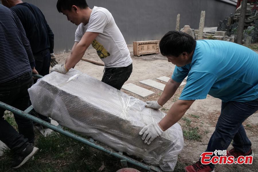 A stone tablet with Emperor Qianlong\'s hand-written words Xi Chun Dong is being relocated before it\'s sent to the Old Summer Palace in Beijing, April 19, 2018. A stone tablet with Emperor Qianlong\'s hand-written words Xi Chun Dong and a stone stele with Emperor Jiaqing\'s writing were moved from the office of the Central Committee of the China Democratic League back to their original sites in the Old Summer Palace, once a complex of royal palaces and gardens. (Photo: China News Service/Cui Nan)