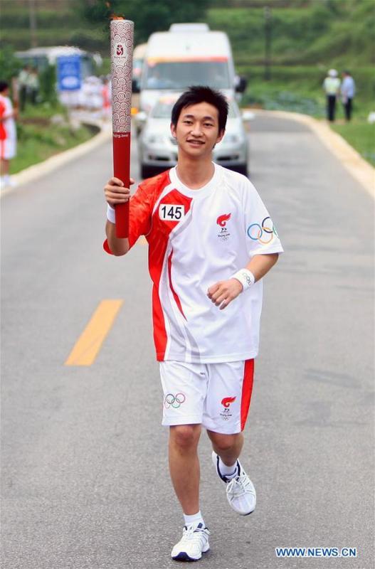 File photo taken on June 13, 2008 shows torchbearer Jiang Yuhang running with the torch during the Beijing Olympic Games torch relay in Kaili City, southwest China\'s Guizhou Province. On May 17, 2008, Jiang, a 20-year-old highway administration employee, was extricated by firefighters, 123 hours after he was trapped in the rubble at quake-hit Yingxiu Township of Wenchuan County, southwest China\'s Sichuan Province. Jiang was a survivor of the 8.0-magnitude earthquake that struck Sichuan\'s Wenchuan County on May 12, 2008. The quake left more than 69,000 dead, 374,000 injured, 18,000 missing and millions homeless. Jiang said it were firefighters who gave him the second life, and he desired to be a soldier like them. At the end of 2008, Jiang realized his dream to join the army and served in the group who once saved him. After training for half a year, he finally became a real fire soldier in Shanghai in 2009. Jiang later got promoted to the position of an officer, and in March this year, he was transferred to the firefighting force in his hometown Kaili City, southwest China\'s Guizhou Province. In the past ten years, the young man, who was saved in that catastrophic earthquake, saved more people\'s lives with his own efforts. (Xinhua/Xing Guangli)