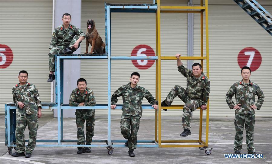 Fire services officer Jiang Yuhang (3rd R) pose for a group photo with other officers and soldiers in Kaili City, southwest China\'s Guizhou Province, May 7, 2018. On May 17, 2008, Jiang, a 20-year-old highway administration employee, was extricated by firefighters, 123 hours after he was trapped in the rubble at quake-hit Yingxiu Township of Wenchuan County, southwest China\'s Sichuan Province. Jiang was a survivor of the 8.0-magnitude earthquake that struck Sichuan\'s Wenchuan County on May 12, 2008. The quake left more than 69,000 dead, 374,000 injured, 18,000 missing and millions homeless. Jiang said it were firefighters who gave him the second life, and he desired to be a soldier like them. At the end of 2008, Jiang realized his dream to join the army and served in the group who once saved him. After training for half a year, he finally became a real fire soldier in Shanghai in 2009. Jiang later got promoted to the position of an officer, and in March this year, he was transferred to the firefighting force in his hometown Kaili City, southwest China\'s Guizhou Province. In the past ten years, the young man, who was saved in that catastrophic earthquake, saved more people\'s lives with his own efforts. (Xinhua/Jiang Hongjing)
