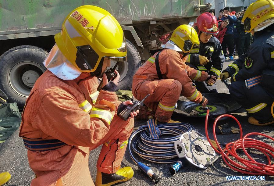 File photo taken on Feb. 5, 2018 shows Jiang Yuhang (1st L) taking part in a rescue mission at a traffic accident site in Shanghai, east China. On May 17, 2008, Jiang, a 20-year-old highway administration employee, was extricated by firefighters, 123 hours after he was trapped in the rubble at quake-hit Yingxiu Township of Wenchuan County, southwest China\'s Sichuan Province. Jiang was a survivor of the 8.0-magnitude earthquake that struck Sichuan\'s Wenchuan County on May 12, 2008. The quake left more than 69,000 dead, 374,000 injured, 18,000 missing and millions homeless. Jiang said it were firefighters who gave him the second life, and he desired to be a soldier like them. At the end of 2008, Jiang realized his dream to join the army and served in the group who once saved him. After training for half a year, he finally became a real fire soldier in Shanghai in 2009. Jiang later got promoted to the position of an officer, and in March this year, he was transferred to the firefighting force in his hometown Kaili City, southwest China\'s Guizhou Province. In the past ten years, the young man, who was saved in that catastrophic earthquake, saved more people\'s lives with his own efforts. (Xinhua)