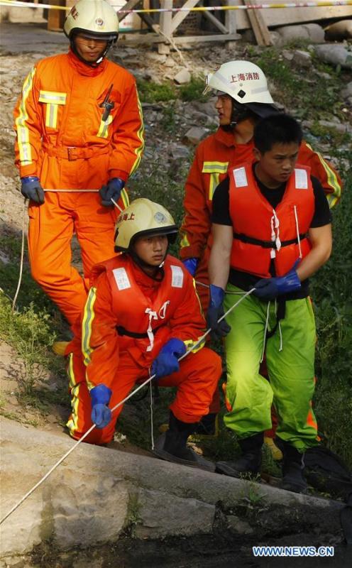 File photo taken on May 7, 2009 shows Jiang Yuhang (L, front) taking part in a rescue mission in Miaohang Township of Shanghai Municipality, east China. On May 17, 2008, Jiang, a 20-year-old highway administration employee, was extricated by firefighters, 123 hours after he was trapped in the rubble at quake-hit Yingxiu Township of Wenchuan County, southwest China\'s Sichuan Province. Jiang was a survivor of the 8.0-magnitude earthquake that struck Sichuan\'s Wenchuan County on May 12, 2008. The quake left more than 69,000 dead, 374,000 injured, 18,000 missing and millions homeless. Jiang said it were firefighters who gave him the second life, and he desired to be a soldier like them. At the end of 2008, Jiang realized his dream to join the army and served in the group who once saved him. After training for half a year, he finally became a real fire soldier in Shanghai in 2009. Jiang later got promoted to the position of an officer, and in March this year, he was transferred to the firefighting force in his hometown Kaili City, southwest China\'s Guizhou Province. In the past ten years, the young man, who was saved in that catastrophic earthquake, saved more people\'s lives with his own efforts. (Xinhua/Zhao Yun)