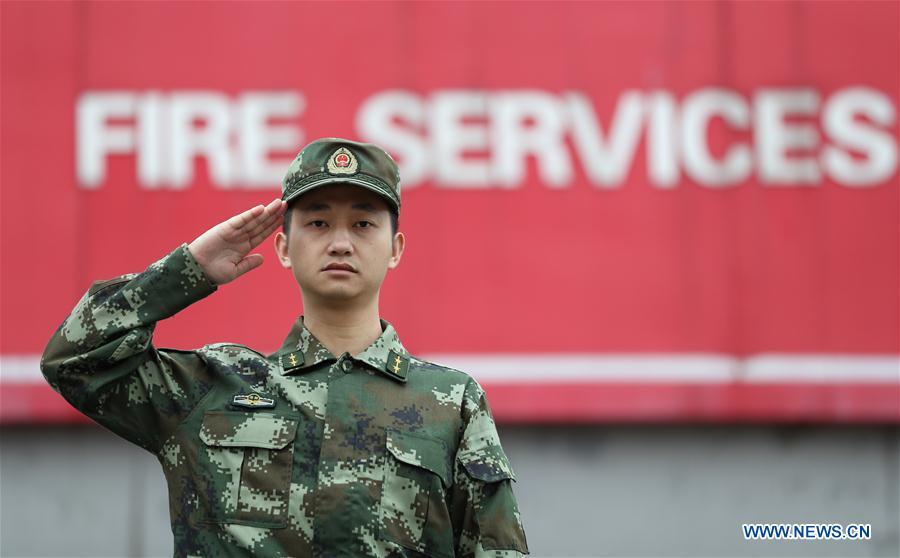 Jiang Yuhang, an officer of a firefighting force, salutes in Kaili City, southwest China\'s Guizhou Province, May 7, 2018. On May 17, 2008, Jiang, a 20-year-old highway administration employee, was extricated by firefighters, 123 hours after he was trapped in the rubble at quake-hit Yingxiu Township of Wenchuan County, southwest China\'s Sichuan Province. Jiang was a survivor of the 8.0-magnitude earthquake that struck Sichuan\'s Wenchuan County on May 12, 2008. The quake left more than 69,000 dead, 374,000 injured, 18,000 missing and millions homeless. Jiang said it were firefighters who gave him the second life, and he desired to be a soldier like them. At the end of 2008, Jiang realized his dream to join the army and served in the group who once saved him. After training for half a year, he finally became a real fire soldier in Shanghai in 2009. Jiang later got promoted to the position of an officer, and in March this year, he was transferred to the firefighting force in his hometown Kaili City, southwest China\'s Guizhou Province. In the past ten years, the young man, who was saved in that catastrophic earthquake, saved more people\'s lives with his own efforts. (Xinhua/Jiang Hongjing)