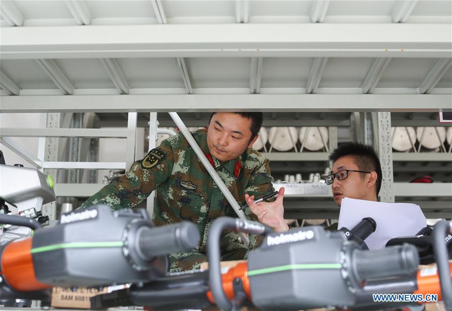 Fire services officer Jiang Yuhang (R) and soldier Xu Songsong check the firefighting equipment in Kaili City, southwest China\'s Guizhou Province, May 8, 2018. On May 17, 2008, Jiang, a 20-year-old highway administration employee, was extricated by firefighters, 123 hours after he was trapped in the rubble at quake-hit Yingxiu Township of Wenchuan County, southwest China\'s Sichuan Province. Jiang was a survivor of the 8.0-magnitude earthquake that struck Sichuan\'s Wenchuan County on May 12, 2008. The quake left more than 69,000 dead, 374,000 injured, 18,000 missing and millions homeless. Jiang said it were firefighters who gave him the second life, and he desired to be a soldier like them. At the end of 2008, Jiang realized his dream to join the army and served in the group who once saved him. After training for half a year, he finally became a real fire soldier in Shanghai in 2009. Jiang later got promoted to the position of an officer, and in March this year, he was transferred to the firefighting force in his hometown Kaili City, southwest China\'s Guizhou Province. In the past ten years, the young man, who was saved in that catastrophic earthquake, saved more people\'s lives with his own efforts. (Xinhua/Jiang Hongjing)