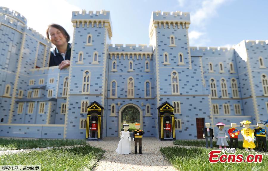 Head model maker Paula Laughton poses for a photograph with a LEGO Windsor Castle replete with royal wedding between Britain\'s Prince Harry and Meghan Markle, in Windsor, Britain May 10, 2018. Legoland\'s specialist model makers built the castle using a staggering 39,960 of the toy bricks. (Photo/Agencies)