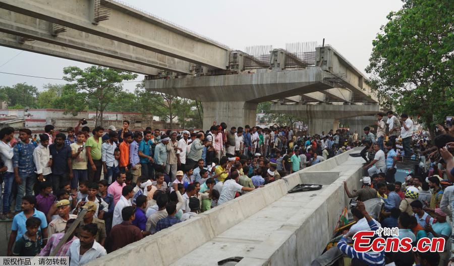 People look for survivors inside vehicles crushed when a section of an under construction overpass collapsed in Varanasi, India, May 15, 2018. A highway overpass that was under construction in north India collapsed Tuesday, killing at least 16 people when an immense concrete slab slammed down onto the crowded road below, disaster officials said. (Photo/Agencies)