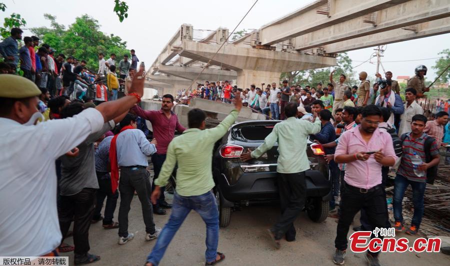 People crowd around the site of an accident where a section of an under construction overpass collapsed in Varanasi, India, May 15, 2018. A highway overpass that was under construction in north India collapsed Tuesday, killing at least 16 people when an immense concrete slab slammed down onto the crowded road below, disaster officials said. (Photo/Agencies)