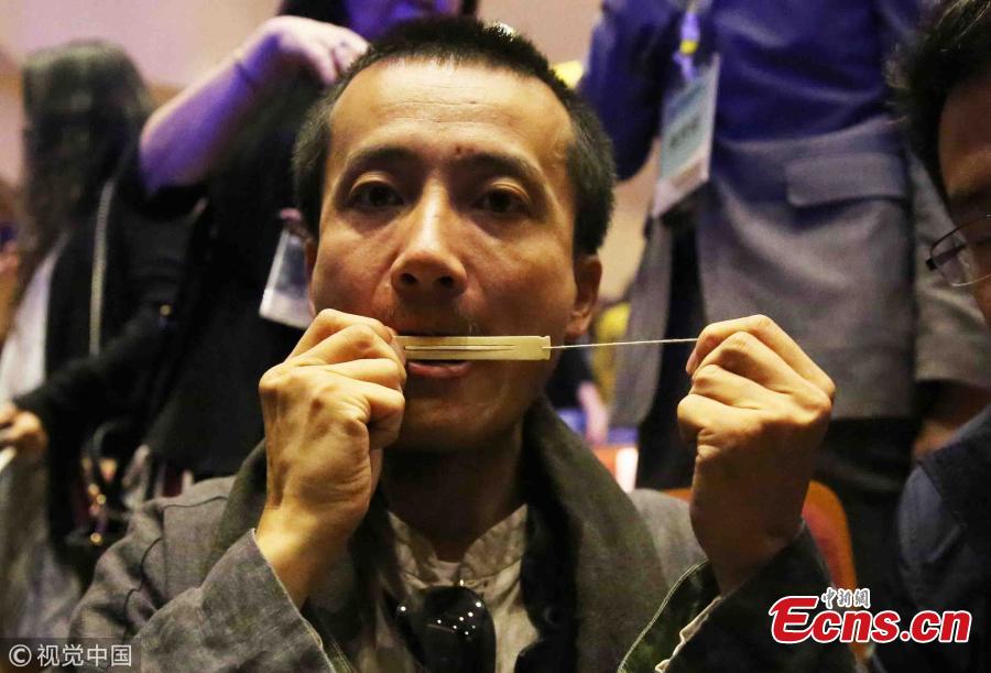 Artist Chen Xuanpeng shows a mouth harp made of bone at the Xi′an Conservatory of Music in Xian City, Northwest China’s Shaanxi Province, May 21, 2018. The musical instrument excavated from the Shimao ruins in Shenmu City measures about 9 centimeters long by 1 centimeter wide and is 2 millimeters thick. It is estimated to have been made 4,000 years ago. Some 20 such mouth harps made of bone were found at the ruins. (Photo/VCG)