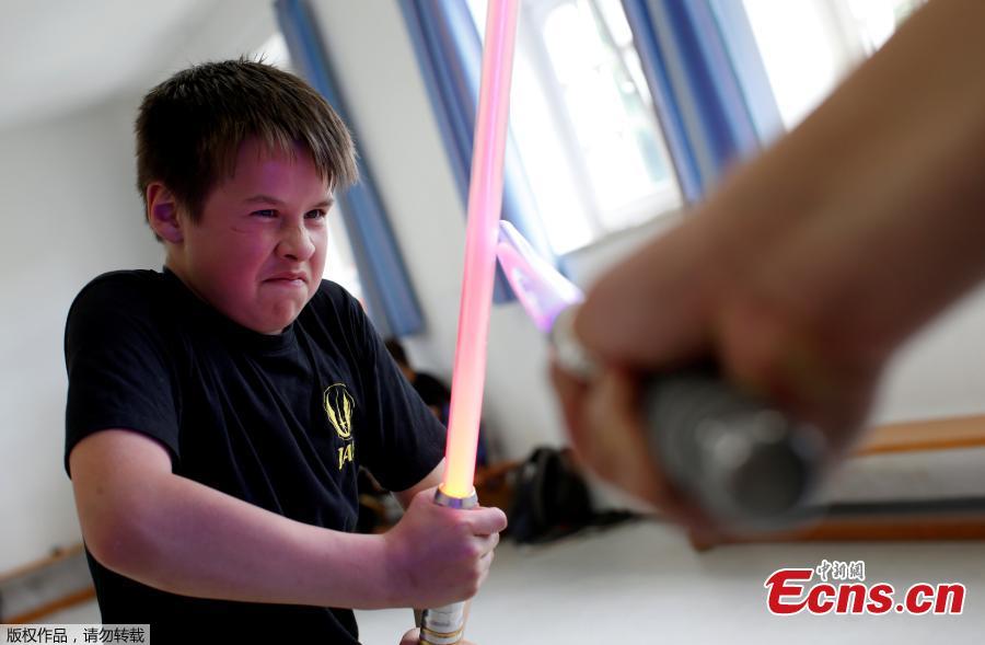 Young people perform during a training session at the \'Jedi Academy Cham\' in Loibling near Cham, Germany, May 19, 2018. The \'Jedi Academy\' is the only registered lightsaber show fight school in Germany. (Photo/Agencies)