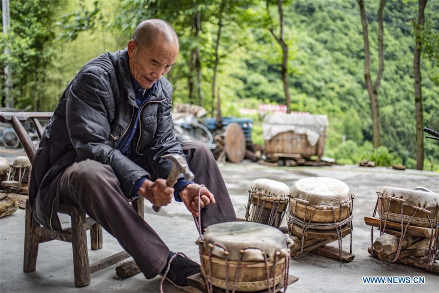 Wu Kaixue makes a Dingtang drum at his courtyard in Longtan Village, Shennongjia of central China\'s Hubei Province, May 21, 2018. Wu Kaixue, who is 75 years old, began to learn the making of Dingtang drums when he was 13. The making of Dingtang drums needs natural resources from the Shennongjia forest and also requires high standard of techniques. Wu makes 100 plus drums in a year and his fame has spread far away. (Xinhua/Du Huaju)