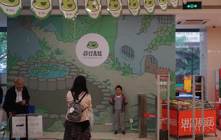 A boy poses in front of a travelling-frog themed background. (Photo: Xiang Jun/GT)