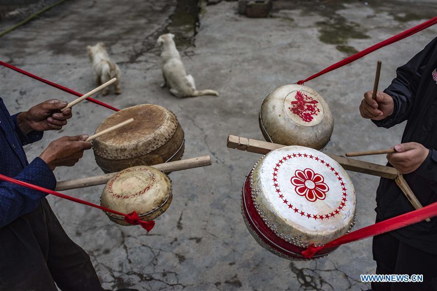 Wu Kaixue shows how to beat the Dingtang drum at his courtyard in Longtan Village, Shennongjia of central China\'s Hubei Province, May 21, 2018. Wu Kaixue, who is 75 years old, began to learn the making of Dingtang drums when he was 13. The making of Dingtang drums needs natural resources from the Shennongjia forest and also requires high standard of techniques. Wu makes 100 plus drums in a year and his fame has spread far away. (Xinhua/Du Huaju)