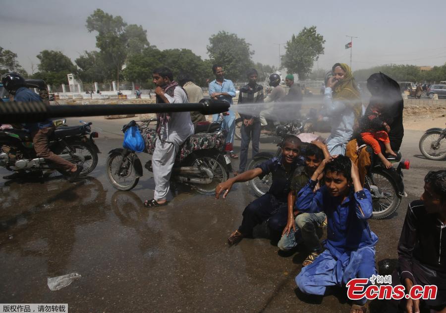 Pakistani volunteer spray water on people to keep them cool in Karachi, Pakistan, May 21, 2018. The Meteorological Department has issued a heat-wave alert for three days. (Photo/Agencies)