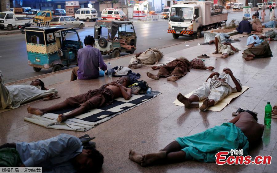 Residents sleep on a building pavement, to escape heat and frequent power outage in their residence area Karachi, Pakistan, May 22, 2018. The Meteorological Department has issued a heat-wave alert for three days. (Photo/Agencies)