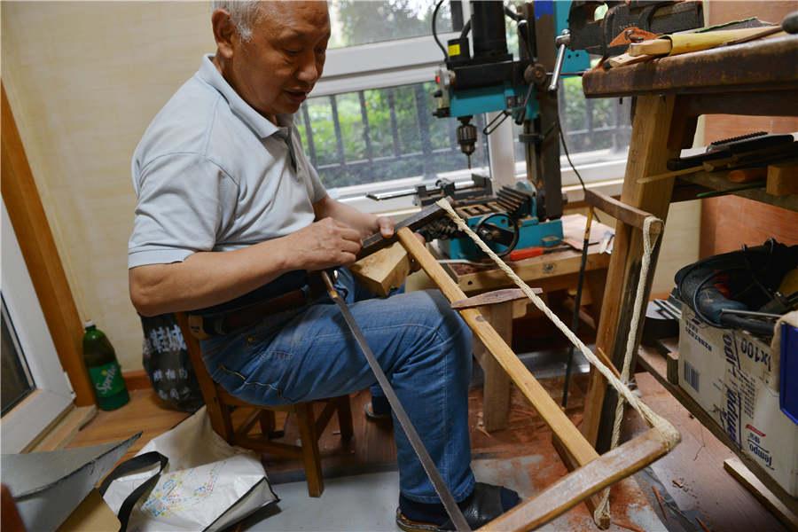 Chen Hesheng makes wooden items using a saw which he has used for 52 years. (Photo/Asianewsphoto)