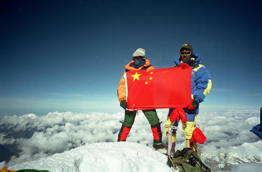 Rinna and Jiji pose on the peak of Mount Qomolangma with Chinese flag on May 27, 1999. They ignited the torch of the 6th National Minority Traditional Sports Games. Rinna and Jiji were the first Chinese couple to reach Mount Qomolangma.  (Photo/Xinhua)