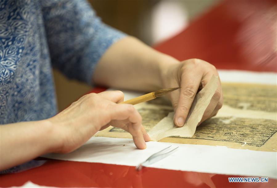 Yan Jingshu restores an ancient book at Zhejiang Library in Hangzhou, east China\'s Zhejiang Province, May 23, 2018. Yan, 55, has worked in the national level ancient book restoration center of the library for 38 years. She and her colleagues collected more than 200 types of paper to restore ancient books. (Xinhua/Weng Xinyang)