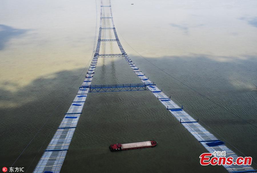 Chinese workers build a bridge over the Yangtze River in Wuhan, capital of central China\'s Hubei Province, May 23, 2018. The bridge stretches in the air, looking like \
