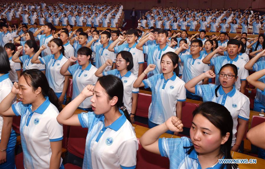 Volunteers take an oath during a launch ceremony for the volunteer program for the upcoming Shanghai Cooperation Organization (SCO) summit in Qingdao, east China\'s Shandong Province, May 24, 2018. About 2,000 volunteers will offer services such as assisting with guests\' arrival and departure, translation, and media requests during the 18th summit of the SCO. (Xinhua/Li Ziheng)