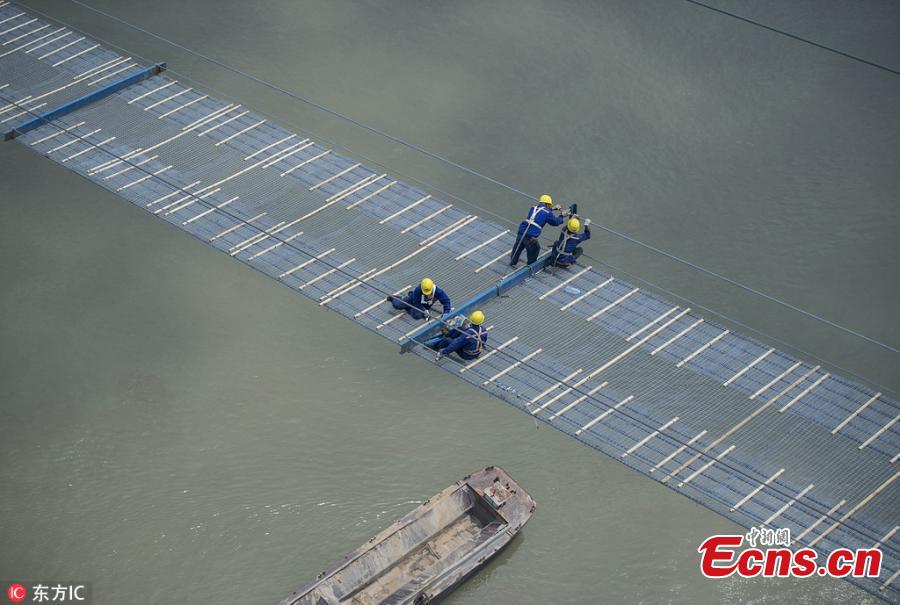 Chinese workers build a bridge over the Yangtze River in Wuhan, capital of central China\'s Hubei Province, May 23, 2018. The bridge stretches in the air, looking like \