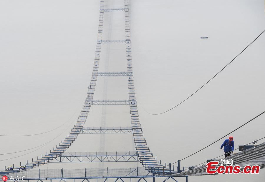 Chinese workers build a bridge over the Yangtze River in Wuhan, capital of central China\'s Hubei Province, May 23, 2018. The bridge stretches in the air, looking like \