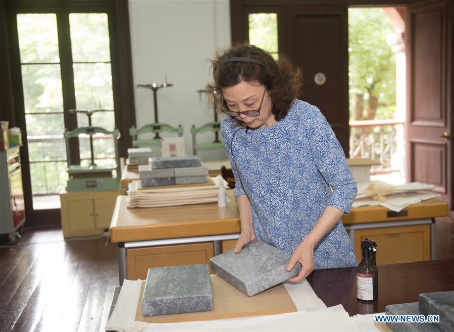 Yan Jingshu planishes an ancient book after restoration at Zhejiang Library in Hangzhou, east China\'s Zhejiang Province, May 23, 2018. Yan, 55, has worked in the national level ancient book restoration center of the library for 38 years. She and her colleagues collected more than 200 types of paper to restore ancient books. (Xinhua/Weng Xinyang)