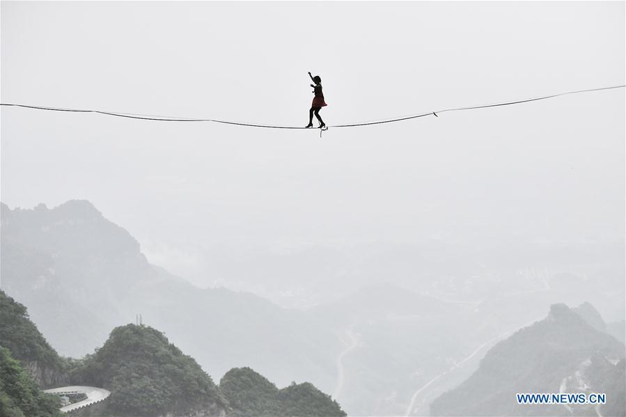 Mimi Guesdon of France participates in a slackline contest in high heels in Zhangjiajie, central China\'s Hunan Province, May 27, 2018. (Xinhua/Shao Ying)