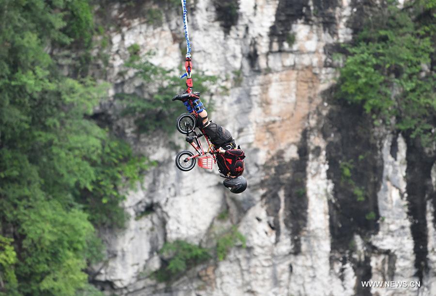 An enthusiast goes bungee jumping from Zhangjiajie Grand Canyon\'s glass-bottom bridge, during a challenge in Zhangjiajie scenic spot, central China\'s Hunan Province, May 26, 2018. Enthusiasts from Russia, Australia, Britain and other countries and regions participated in the challenge on Saturday. (Xinhua/Yan Yuan)