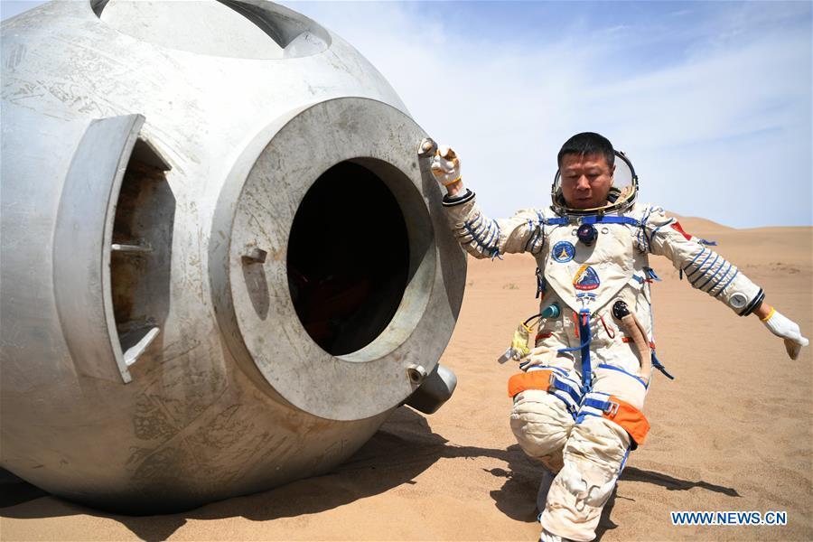 Taikonaut Liu Wang exits from a re-entry capsule during a wilderness survival training in the Badain Jaran Desert in northwest China\'s Gansu Province, May 17, 2018. Fifteen Chinese taikonauts have just completed desert survival training deep in the Badain Jaran Desert near Jiuquan Satellite Launch Center in northwest China. Organized by the Astronaut Center of China (ACC), the program was designed to prepare taikonauts with the capacity to survive in the wilderness in the event their re-entry capsule lands off target. (Xinhua/Chen Bin)