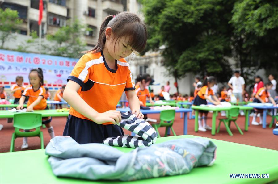 Children participate in a household skills contest at a kindergarten in Huaying, southwest China\'s Sichuan Province, May 29, 2018. Various activities were held across China to celebrate the upcoming International Children\'s Day. (Xinhua/Qiu Haiying)