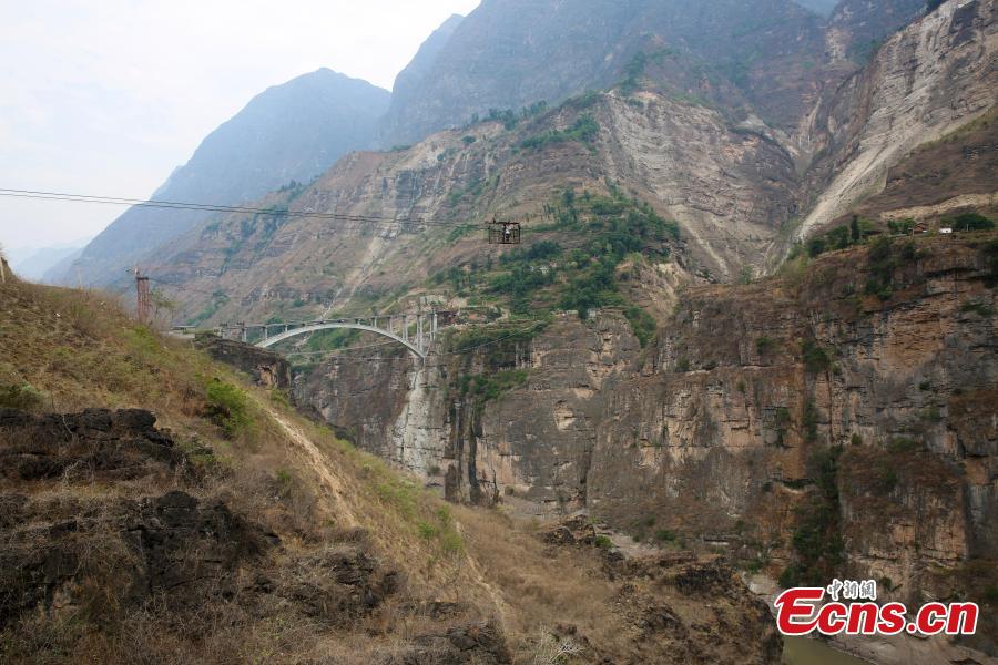 Photo taken on May 30, 2018 shows the Yingge Bridge under construction over the Jinsha River between Yingge Village in Qiaojia County, Yunnan Province and Yanjiang Village in Liangshan Prefecture, Sichuan Province. Construction of the majority of the bridge was completed Wednesday. Until now, a 470-meter cableway 260 meters above the river had served as the main transport option for villagers. It is known as the highest of its kind in Asia. In November 2015, authorities began building the bridge to improve local transport. The new bridge will be nine meters wide, 385.5 meters long, and 200 meters above the river. (Photo: China News Service/Yan Keren)