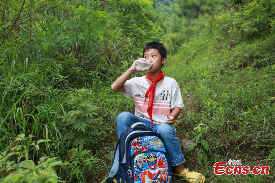 Li Jianwen, 10, is on his way to Dayadong Primary School in Liucheng County, South China’s Guangxi Zhuang Autonomous Region, May 31, 2018. It takes Li about one and a half hours to climb the mountain to his school, a three-hour return commute each day. (Photo: China News Service/Zhu Liurong)