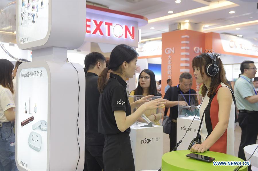 A visitor (front, R) experiences products of an exhibitor at the 2018 Beijing International Audiology Conference in Beijing, capital of China, June 2, 2018. The 2018 Beijing International Audiology Conference kicked off here Saturday. (Xinhua/Lu Peng)