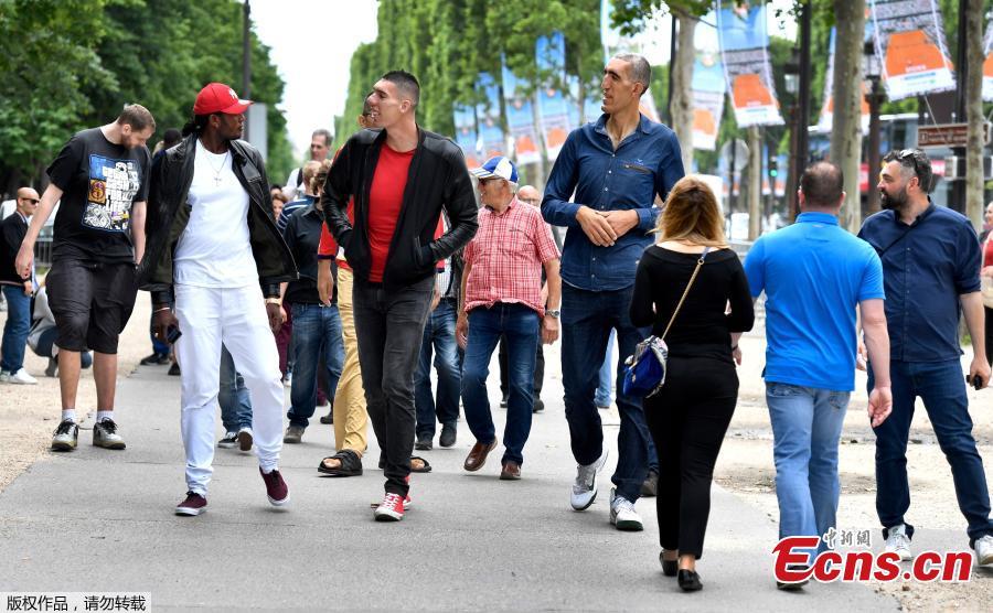 Some of the world\'s tallest men walk on the Champs-Elysees Avenue in Paris, on June 1, 2018, during a meeting of world tallest men. (Photo/Agencies)