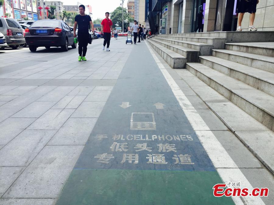 A special lane for phubbers who are busy with phones or mobile devices wherever they go has been built in Xi’an, Northwest China’s Shaanxi Province. The one-meter-wide lane is said to improve safety for those who constantly lower their heads and gaze into the cellphones, but some citizens frown on the idea. (Photo: China News Service/Chen Ying)