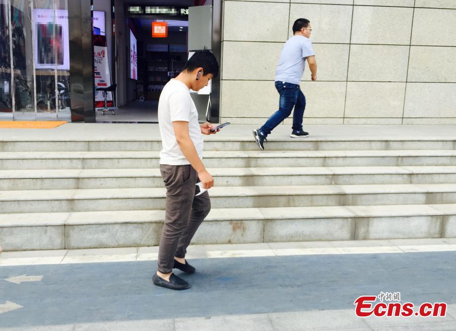 A special lane for phubbers who are busy with phones or mobile devices wherever they go has been built in Xi’an, Northwest China’s Shaanxi Province. The one-meter-wide lane is said to improve safety for those who constantly lower their heads and gaze into the cellphones, but some citizens frown on the idea. (Photo: China News Service/Chen Ying)