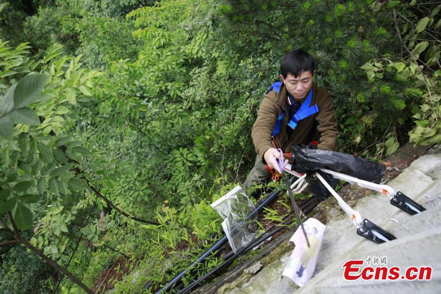 Sanitary worker Liu Wenhua collects garbage on a cliff while hanging from a cable at Wulingyuan scenic area in Zhangjiajie City, Central China’s Hunan Province, June 5, 2018. Liu, 48, has worked at the tourist attraction for nearly five years, mainly responsible for cleaning litter left by irresponsible visitors. (Photo: China News Service/Wu Yongbing)