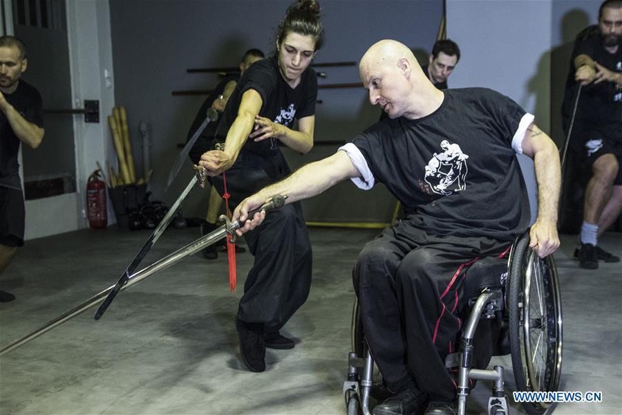 Kostas Moukas (front), a disabled Wushu teacher, teaches in his wheelchair, in Athens, Greece, June 5, 2018. Kostas Moukas started practicing Wushu since 2003 and is the only Wushu teacher in a wheelchair in Greece. He trains mixed classes that include seven disabled athletes who compete officially in the national championships. (Xinhua/Panagiotis Moschandreou)