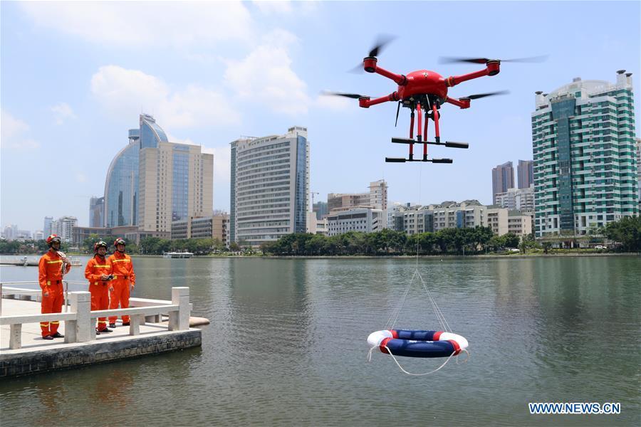 Firefighters use a drone to deliver a lifebuoy during a rescue drill on a lake in Xiamen of southeast China\'s Fujian Province, May 25, 2018. Over the last few years, unmanned aerial vehicles (UAVs) have increasingly embedded in everyday life all around China. The duties of these civil drones range from agriculture, transportation to entertainment. The commercial sector relies on unmanned platforms for a variety of services, including aerial photography, crop monitoring, rescuing, delivering and performances. The wide use of drones not only makes life more convenient, but also broadens the imagination of Chinese people towards the coming future. (Xinhua/Zeng Demeng)