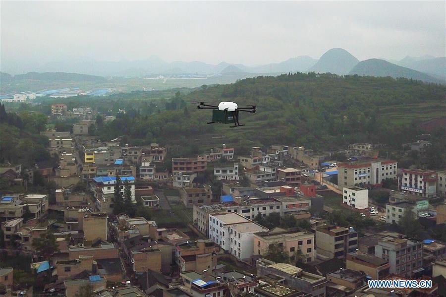 Aerial photo taken on May 10, 2018 shows a drone carried with parcels, taking off from a branch post office in Weicheng Township, Qingzhen City of southwest China\'s Guizhou Province. Over the last few years, unmanned aerial vehicles (UAVs) have increasingly embedded in everyday life all around China. The duties of these civil drones range from agriculture, transportation to entertainment. The commercial sector relies on unmanned platforms for a variety of services, including aerial photography, crop monitoring, rescuing, delivering and performances. The wide use of drones not only makes life more convenient, but also broadens the imagination of Chinese people towards the coming future. (Xinhua/Liu Xu)